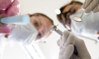 To tandlæger står over kameraet med deres værktøj i hænderne