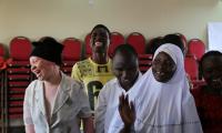 Unge workshopdeltagere griner i Uganda